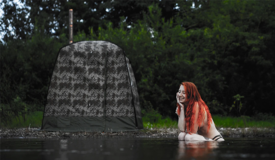 Cooling off in the river beside a tent sauna