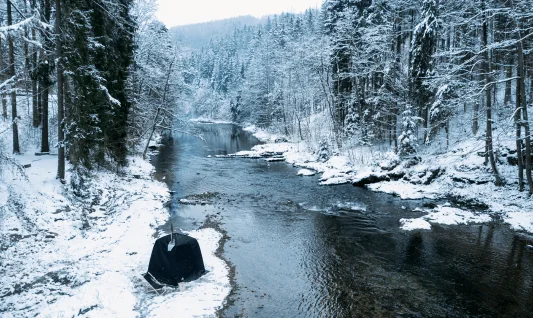 Tent sauna by a snowy river