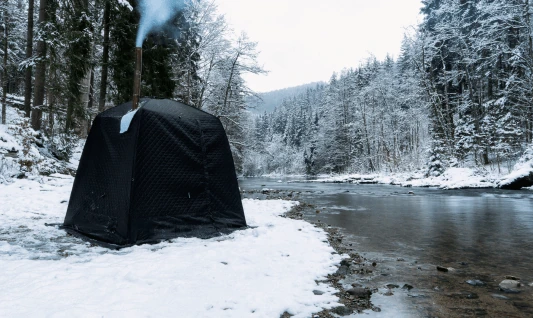 Tent sauna beside a snowy river